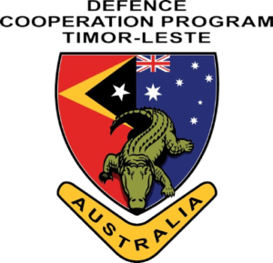 shield with Timorese flag on the left and australian flag on the right. A cocodile in the middle. A boomerang underneath